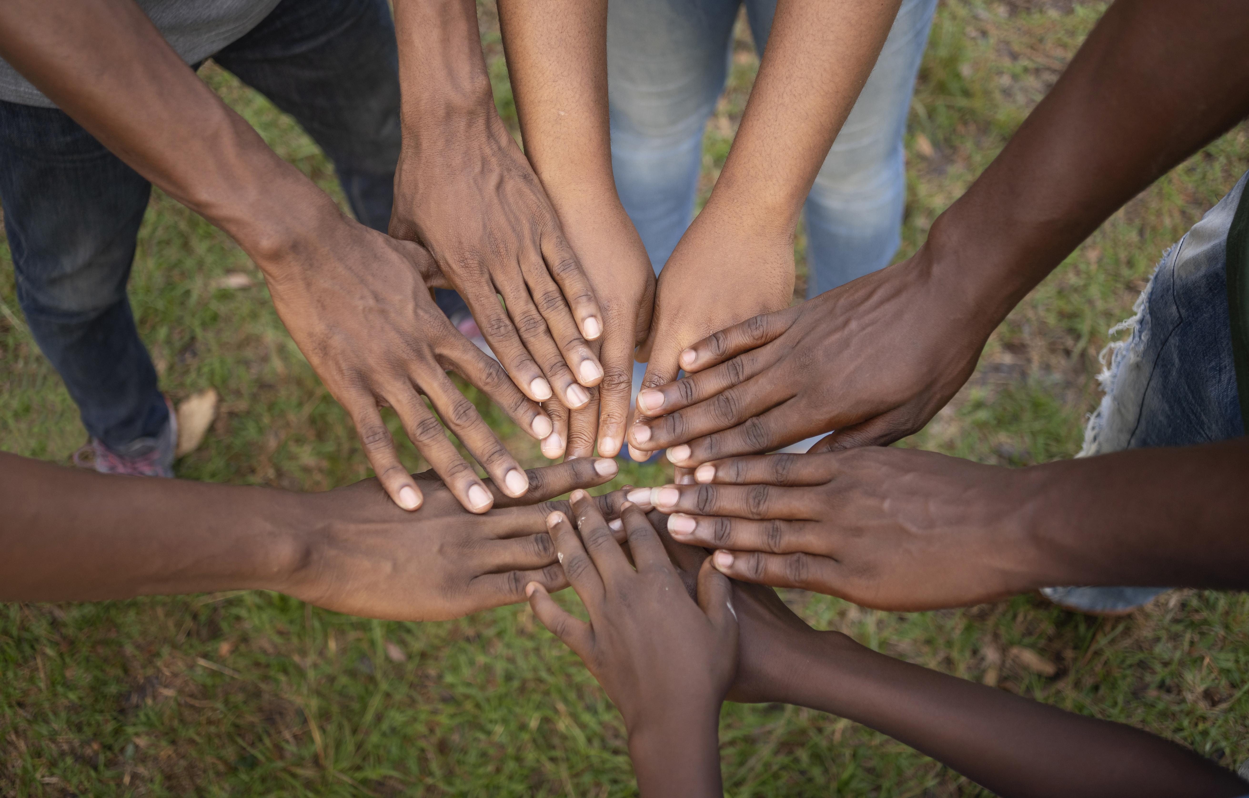 Hands of community members placed together
