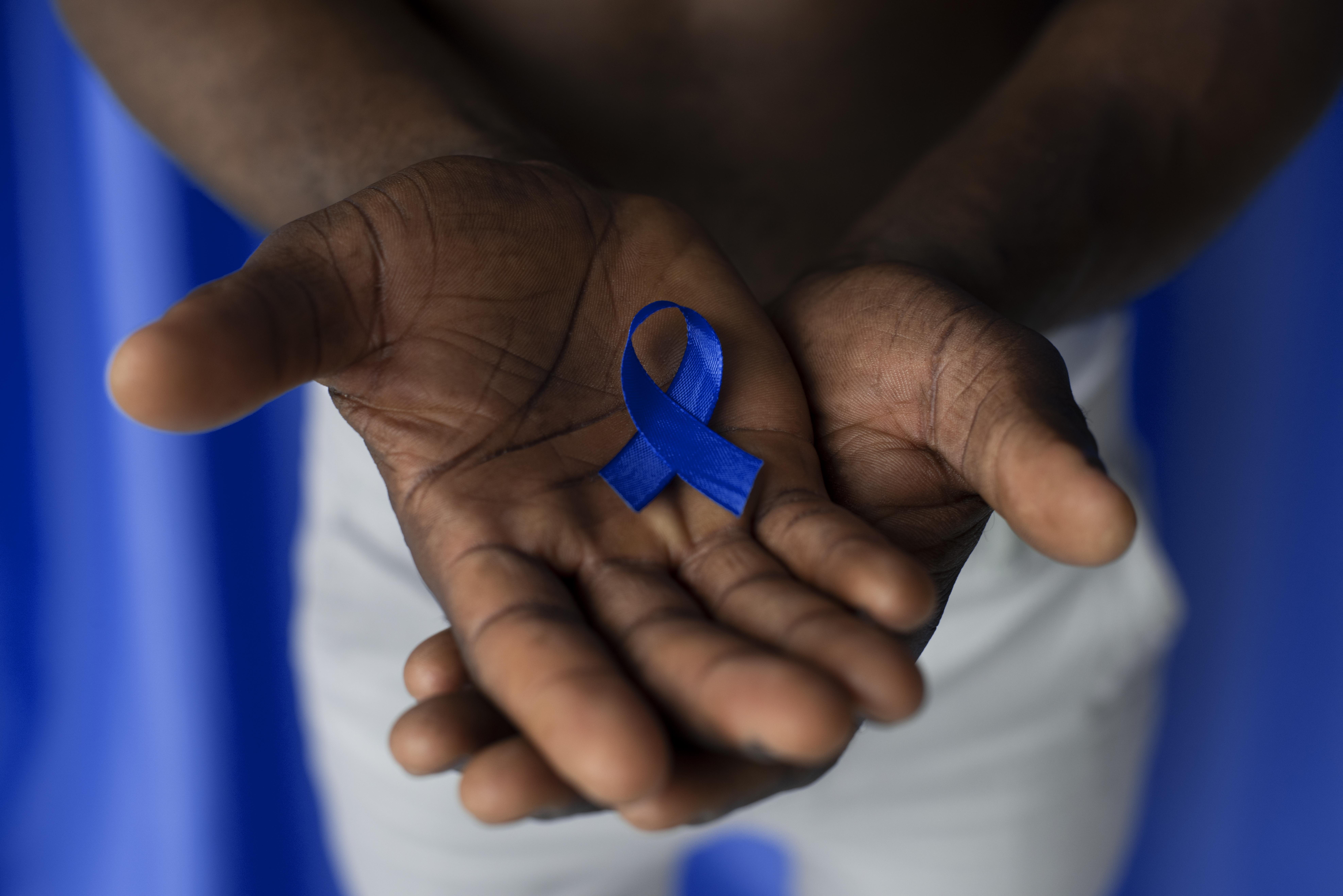A man holding an awareness ribbon